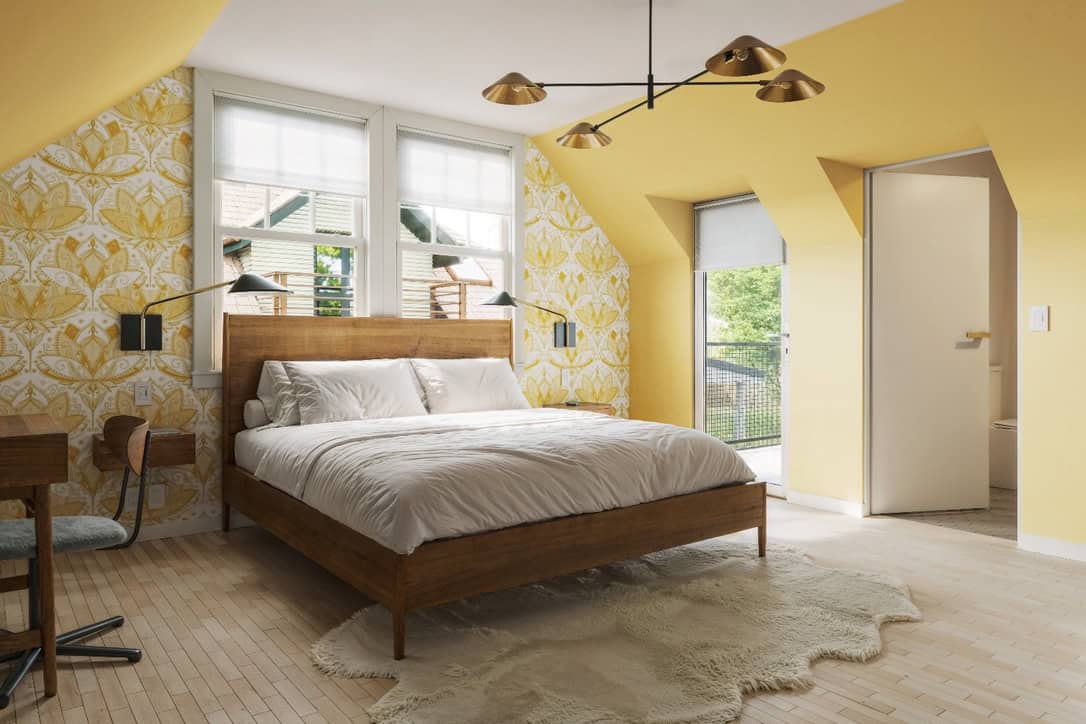 Cozy Einstein Room at Assemble Boise with queen bed, yellow accent walls, bird-inspired wallpaper, and private terrace