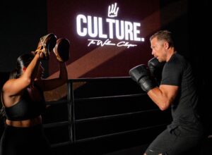Boxing workout in private studio. Man and woman boxing with pads, fitness training session at Assemble Boise. Culture wellness.