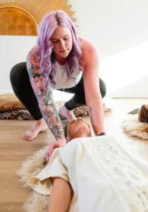 Breathwork session in Boise: Woman guides another in relaxation. Holistic wellness and mindful breathing for stress relief.