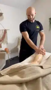 Boise massage therapy: Man giving a leg massage. Relaxing spa treatment for pain relief and wellness in Boise.
