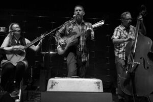 Assemble Boise music experience: Band performs live with banjo, guitar, and bass in black and white. Great live music!