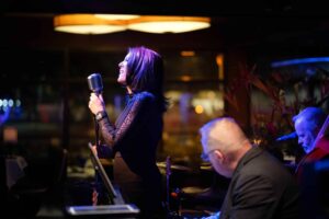 Private dining Boise: Live music with a female singer performing with a band in an elegant restaurant setting.