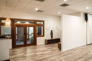 Assemble Boise Yoga Class entrance with wood floors, coat rack, and inviting studio space. Modern yoga studio design.
