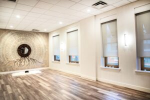 Bright yoga class studio in Boise with mandala wall art, wood floors, and window light. Ready for yoga poses.