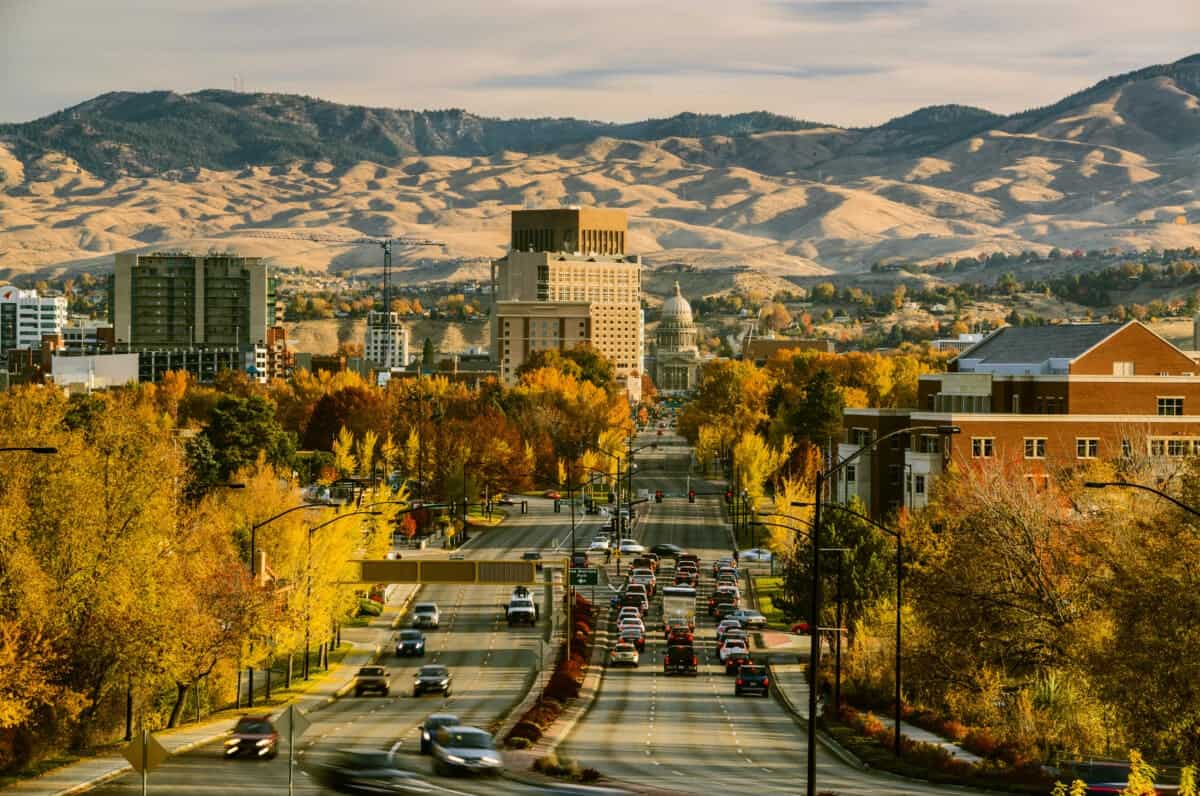 Where to stay in Boise, ID — downtown skyline view with autumn trees, city streets, and Boise foothills in the background.